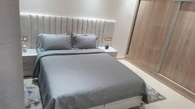 a bedroom with a large bed and a sink at Chez bousfyha 2 in Marrakech