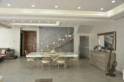 a dining room with a table and a staircase at Atlas Royale Marrakech in Marrakech
