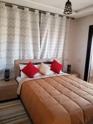 a bedroom with a large bed with red pillows at Magnifique appartement in Marrakech