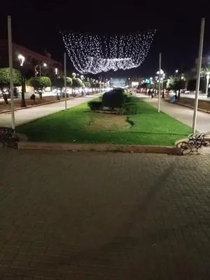a park at night with lights on a street at Magnifique appartement in Marrakech
