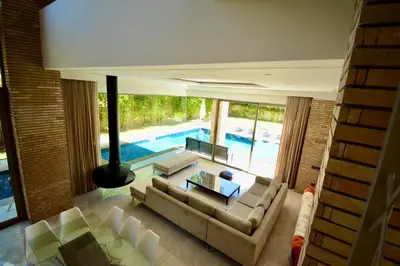 a living room with a couch and a table and a pool at Villa MAÙRA Marrakech in Marrakech