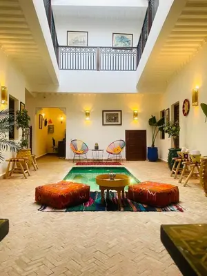 a pool with a table and some chairs and a table at Riad dei colori in Marrakech