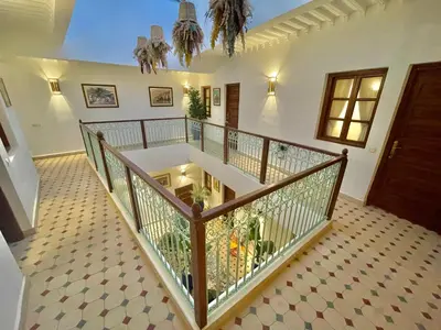 a staircase in a house with a wooden railing at Riad dei colori in Marrakech