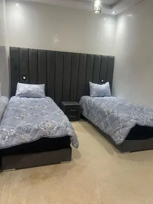a bedroom with two beds and a large headboard at Riad Arfoud appartement haut standing 3 chambres avec piscine à gueliz nord in Marrakech