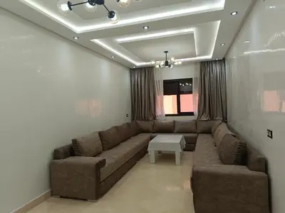 a living room with a couch and a table at Riad Arfoud appartement haut standing 3 chambres avec piscine à gueliz nord in Marrakech
