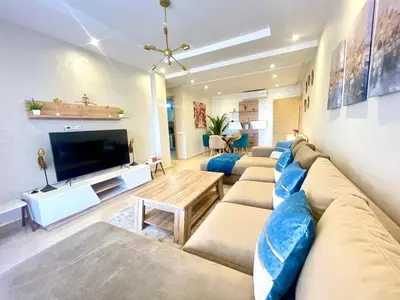 a living room with a large couch and a television at Les Douces Nuits De Marrakech in Marrakech