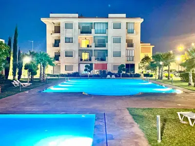 a large building with a swimming pool in front of it at Les Douces Nuits De Marrakech in Marrakech