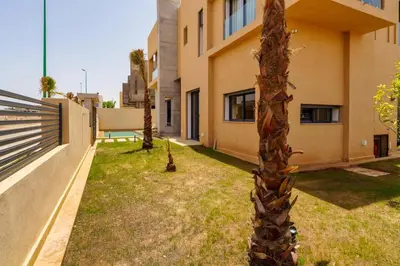 a palm tree in a yard next to a building at Sublime Villa A in Marrakech