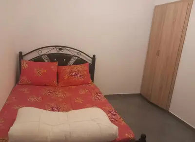 a bedroom with a bed with a red blanket and pillows at Apartment - Sleeps up to 8 & parking in Marrakech