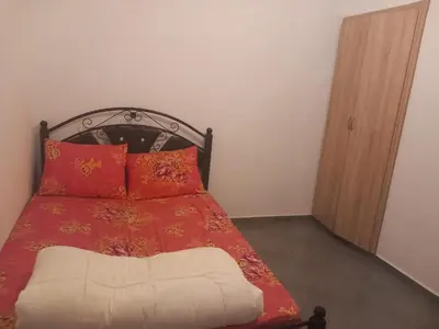 a bedroom with a bed with a red blanket and pillows at Apartment - Sleeps up to 8 & parking in Marrakech