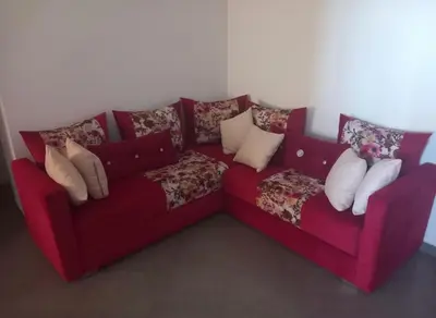 a red couch with pillows on it in a room at Apartment - Sleeps up to 8 & parking in Marrakech
