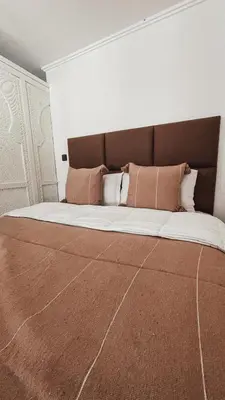a large bed with pillows on it in a bedroom at Duplex Jasmine in Marrakech