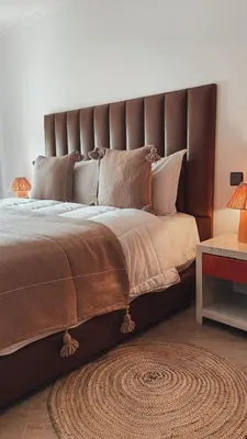 a large bed with a brown headboard in a bedroom at Duplex Jasmine in Marrakech