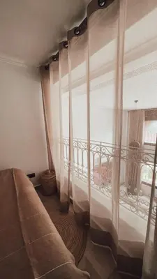 a room with a bed and a window with curtains at Duplex Jasmine in Marrakech