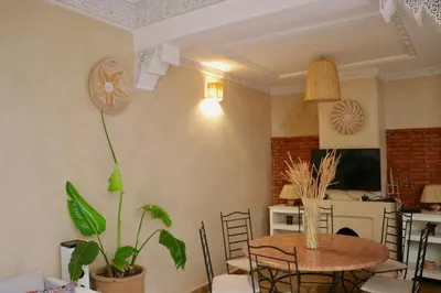 a living room with a table and a dining room at Riad CHEZ MOI in Marrakech