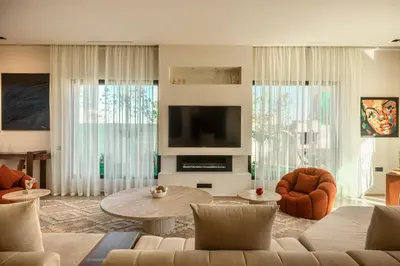 a living room with a couch and a tv at Somptueuse Family Villa Cherifa avec piscine chauffée in Marrakech
