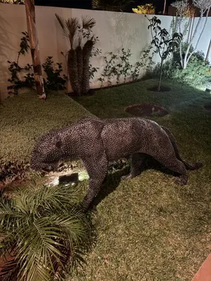 a statue of a dog standing on the grass at Somptueuse Family Villa Cherifa avec piscine chauffée in Marrakech