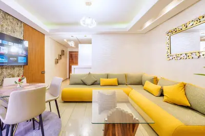 a living room with a yellow couch and a table at Menara garden in Marrakech