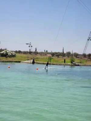a man is standing in the water in a lake at les jardins d'atlas waky palm golf in Marrakech