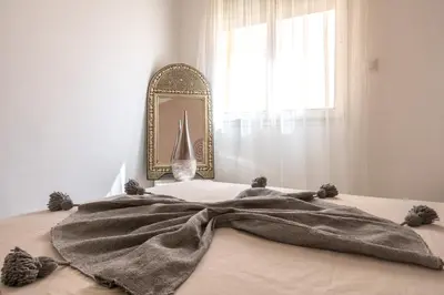 a blanket on top of a bed with a mirror at Appartamento 14 a Guelize Hivernage in Marrakech
