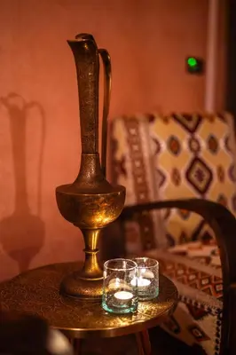 a vase and two candles on a table with a couch at Alrashid Marrakech Boutique Hotel & SPA in Marrakech