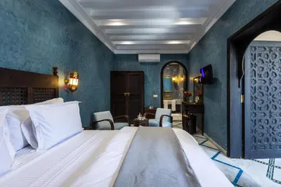 a bedroom with a large bed and blue walls at Alrashid Marrakech Boutique Hotel & SPA in Marrakech