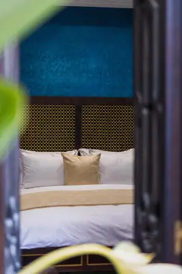 a bed with white sheets and pillows in a room at Alrashid Marrakech Boutique Hotel & SPA in Marrakech