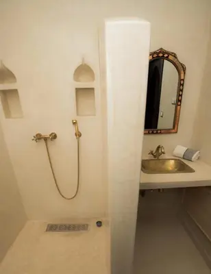 a bathroom with a sink and a shower and a mirror at Villa Dar AL Manel in Aït Amara