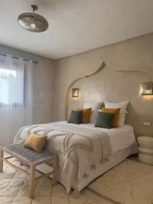 a bedroom with a large bed and a table at Villa Dar AL Manel in Aït Amara