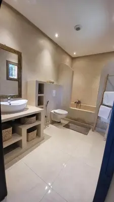 a bathroom with a sink and a toilet and a tub at Villa Dar AL Manel in Aït Amara