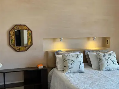 a bedroom with a bed with pillows and a mirror at Villa Kela Serene in Marrakech