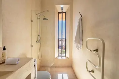 a bathroom with a shower and a toilet and a window at Villa Kela Serene in Marrakech