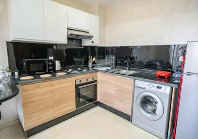 a kitchen with a sink and a washing machine at Appart Mayar 52 in Marrakech