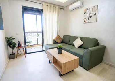 a living room with a green couch and a coffee table at Appart Mayar 52 in Marrakech
