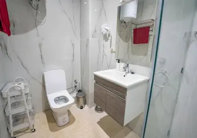 a white bathroom with a toilet and a sink at Appart Mayar 52 in Marrakech