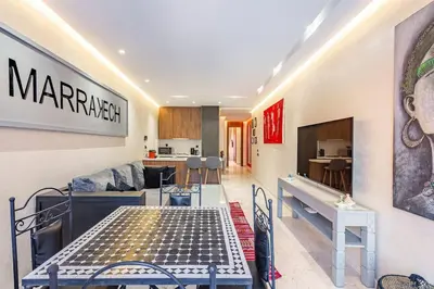 a living room with a table and a kitchen at New ! Bright And Comfortable App in city center in Marrakech