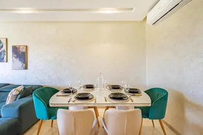 a dining room with a table and a blue couch at Résidence Golfique ,Piscine,Jardin terrasse privée in Marrakech