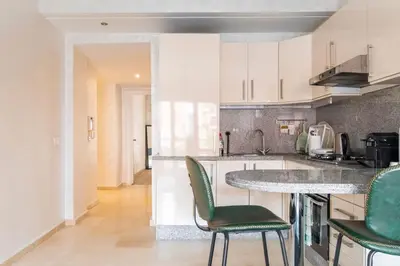 a kitchen with green chairs and a counter top at Appartement Miramas 2 Gueliz pool,Gym in Marrakech