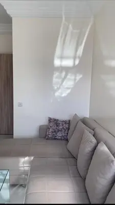a living room with a couch in a white room at appartement de luxe a Marrakech in Marrakech