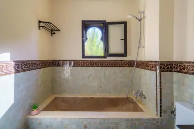 a bath tub in a bathroom with a window at Villa Riad Sultana in Marrakech
