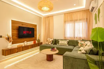 a living room with a green couch and a tv at Cozy appartement à Gueliz juste les familles in Marrakech