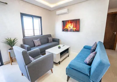 a living room with a couch and chairs and a fireplace at Appart Mayar 58 in Marrakech