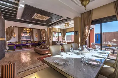 a dining room with a table with wine glasses at Villa Akadia luxurious with private swimming pool in Marrakech