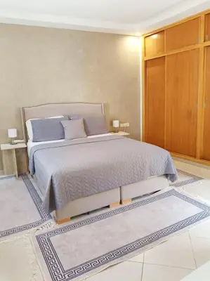 a bedroom with a large bed with blue pillows at Family House Marrakech in Marrakech
