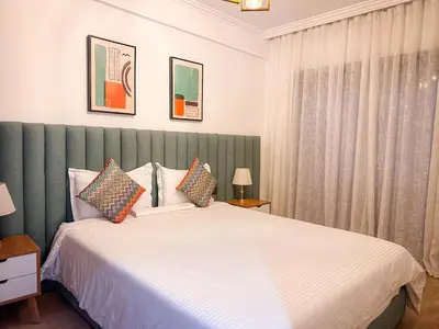 a bedroom with a large bed with a green headboard at Bel appartement haut standing in Marrakech