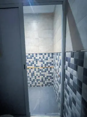 a bathroom with a walk in shower with blue and white tiles at Your Home Away From Home in Marrakech
