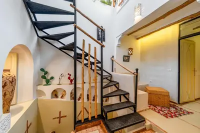a spiral staircase in a home with white walls at Dar Karole-Privé-petits déjeuners inclus in Marrakech