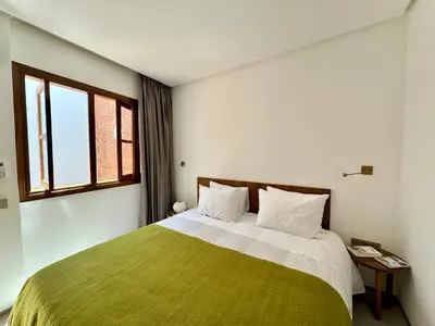 a bedroom with a large bed with a green blanket at Riad Ziya - Private very close to Jamaa El Fna in Marrakech