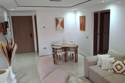 a living room with a table and a couch at Hypercentre, Cosy, 2 piscines, Sauna, Hammam in Marrakech