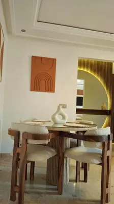 a dining room table with two chairs and a mirror at Hypercentre, Cosy, 2 piscines, Sauna, Hammam in Marrakech